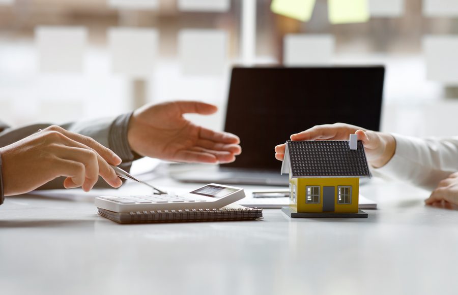 A model house and a calculator on a banker's desk